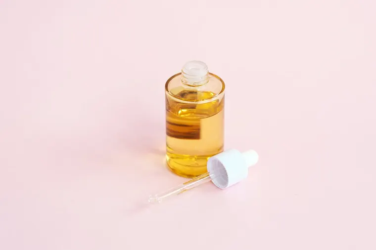 Sérum facial sobre fondo rosa